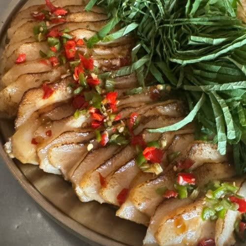 노릇하게 구운 통항정살을 부채처럼 저며 담고 청양고추와 홍고추 다진 것을 올린 접시. 곁에 깻잎채가 수북하다